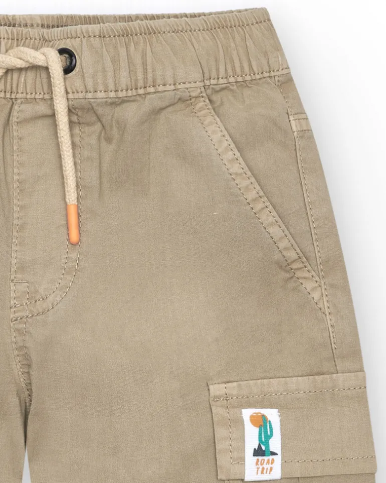 Bermuda cargo para niño en color beige con bolsillos laterales y cintura ajustable.