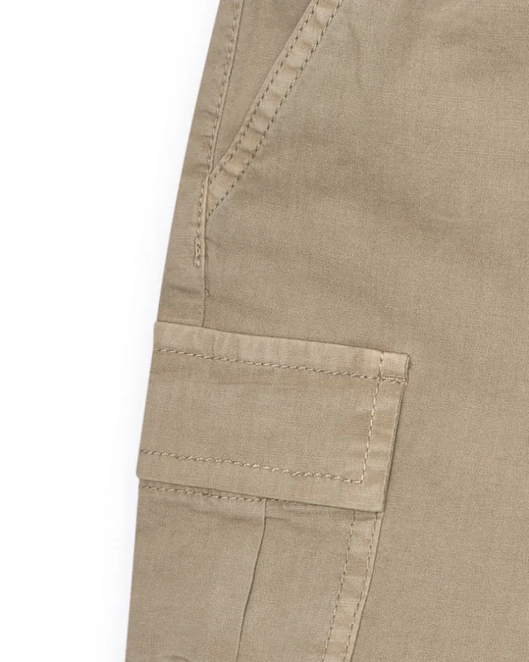 Bermuda cargo para niño en color beige con bolsillos laterales y cintura ajustable.
