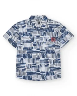 Camisa para niño en blanco con estampado geométrico azul y bolsillo decorativo.