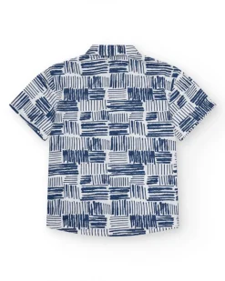 Camisa para niño en blanco con estampado geométrico azul y bolsillo decorativo.