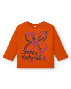 Camiseta de niña en naranja con estampado floral y texto colección Super Natural