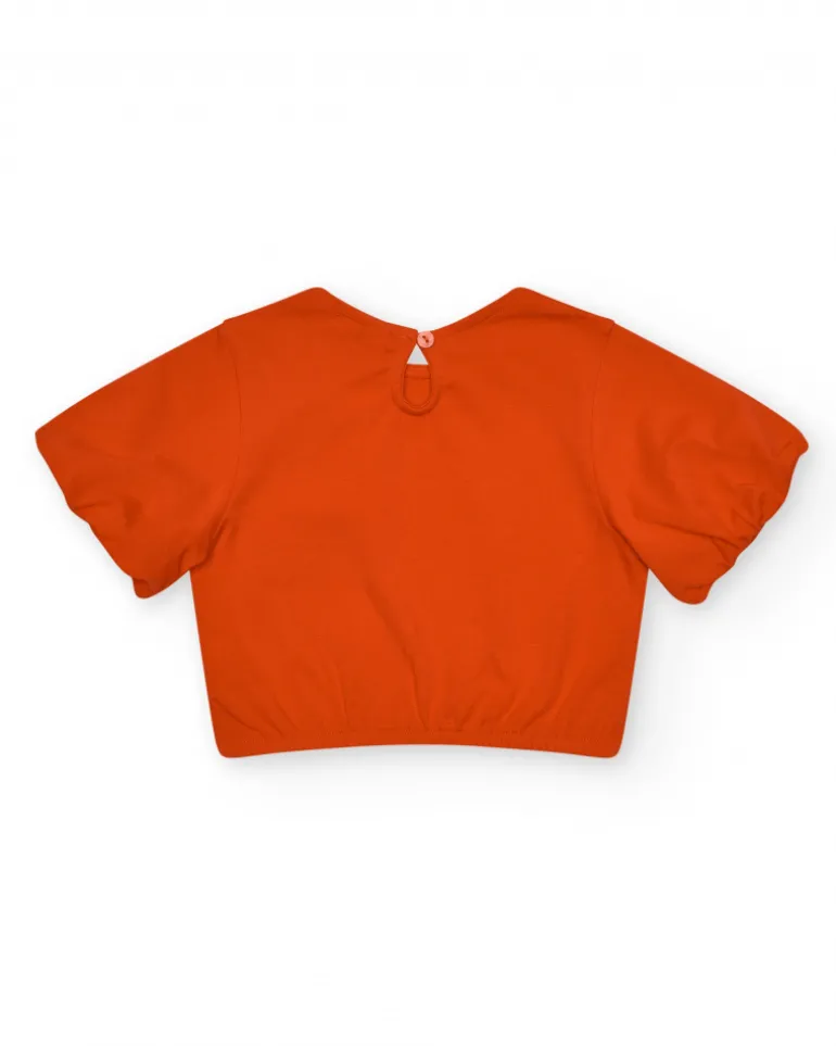 Camiseta naranja para niña con flor y mangas abullonadas