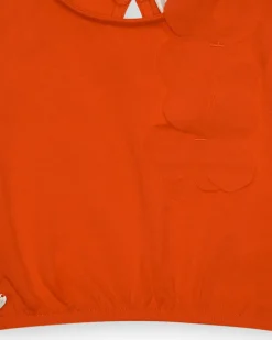 Camiseta naranja para niña con flor y mangas abullonadas