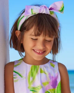 Diadema para niña en tonos lilas con lazo decorativo.