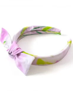 Diadema para niña en tonos lilas con lazo decorativo.