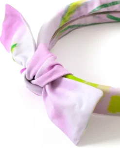 Diadema para niña en tonos lilas con lazo decorativo.