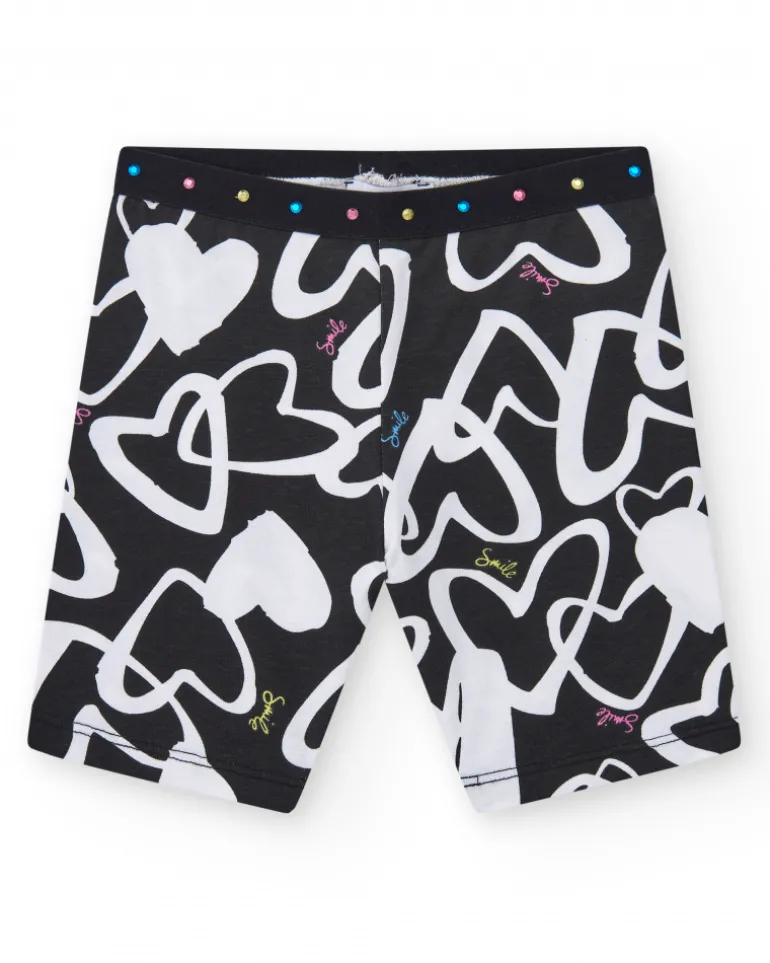 Legging ciclista para niña en negro con corazones estampados y cintura decorada con tachuelas