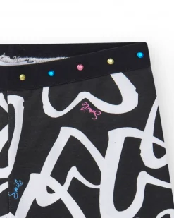 Legging ciclista para niña en negro con corazones estampados y cintura decorada con tachuelas