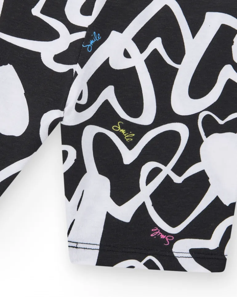 Legging ciclista para niña en negro con corazones estampados y cintura decorada con tachuelas